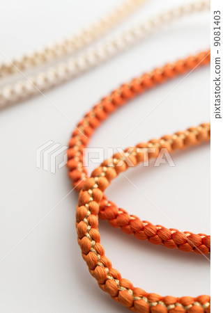 Close-up of an orange, round-braided obi sash. Close-up of an orange, round-braided obi sash. 9081403