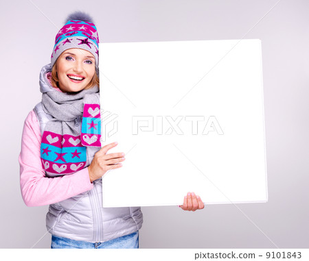 Adult smiling  woman in winter hat holds the white banner 9101843