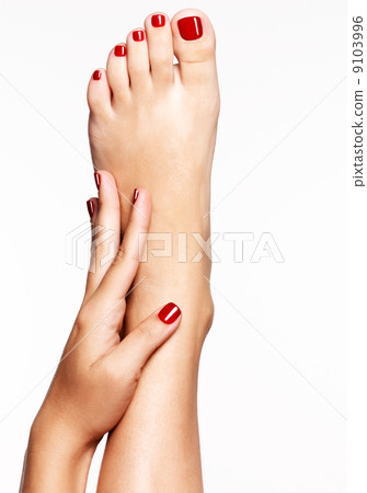 Closeup photo of a female feet with beautiful red pedicure 9103996