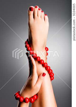 Closeup photo of a beautiful female feet with red pedicure Closeup photo of a beautiful female feet with red pedicure 9104005