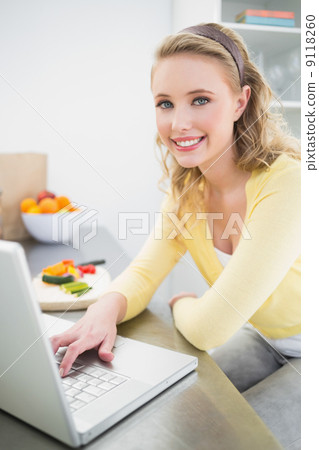 Cheerful smiling cute blonde using laptop Cheerful smiling cute blonde using laptop 9118260