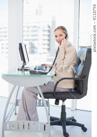 Smiling blonde businesswoman on the phone 9118758