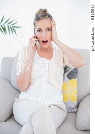 Shocked fresh blonde in white clothes on the phone 9118983