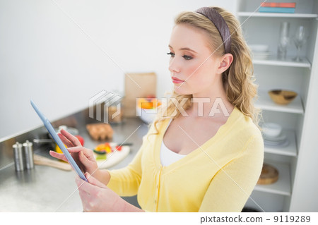 Content cute blonde using tablet 9119289