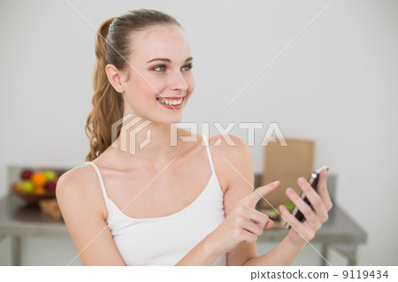 Smiling young woman holding smartphone 9119434