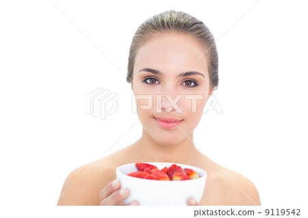 Smiling young brunette woman holding a bowl of strawberries 9119542