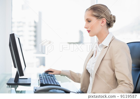 Peaceful blonde businesswoman working on computer 9119587
