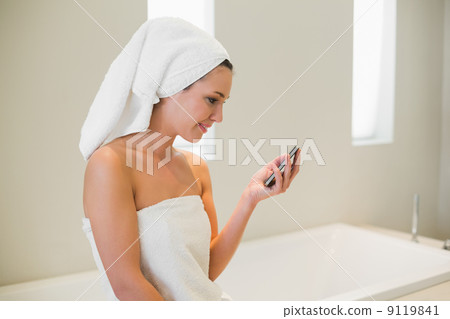 Joyful natural brown haired woman using a mobile phone 9119841