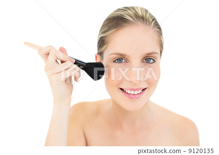 Pleased fresh blonde woman applying powder on her cheeks Pleased fresh blonde woman applying powder on her cheeks 9120135