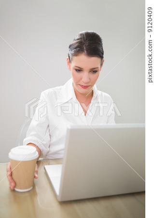 Pensive gorgeous businesswoman working on laptop Pensive gorgeous businesswoman working on laptop 9120409