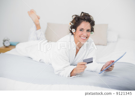 Smiling natural brunette using tablet and credit card 9121345