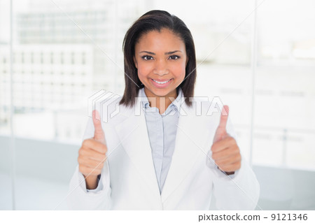 Pleased young dark haired businesswoman giving thumbs up 9121346