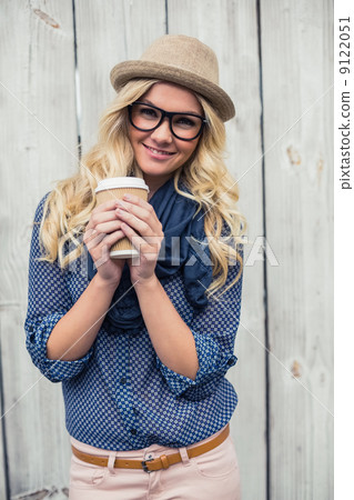 Happy trendy blonde holding coffee outdoors Happy trendy blonde holding coffee outdoors 9122051
