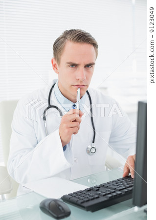 Male doctor using computer at medical office Male doctor using computer at medical office 9123049