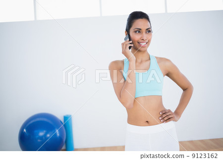 Lovely smiling woman posing with hand on hip while phoning Lovely smiling woman posing with hand on hip while phoning 9123162
