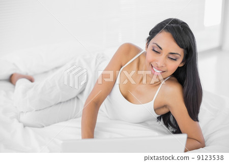 Attractive woman lying on her bed 9123538