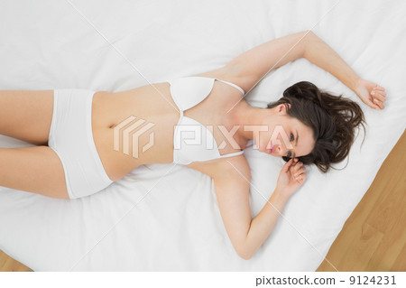 Beautiful young woman lying in lingerie on bed 9124231
