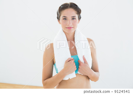 Fit woman with towel around neck at fitness studio Fit woman with towel around neck at fitness studio 9124541