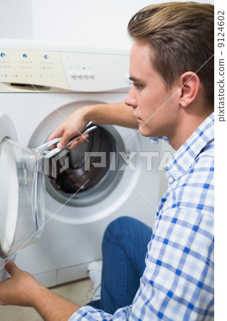 Technician repairing a washing machine Technician repairing a washing machine 9124602