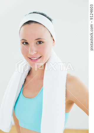 Slender woman with towel around neck in fitness studio 9124603