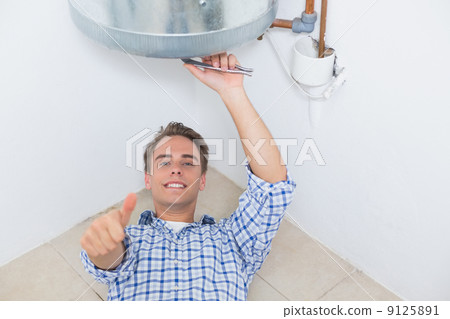 Technician gesturing thumbs up by hot water heater 9125891