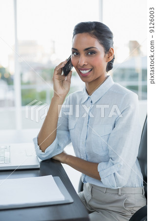Pretty businesswoman phoning with smartphone smiling at camera 9126003