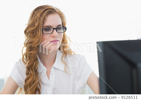 Serious businesswoman using computer in office Serious businesswoman using computer in office 9126511