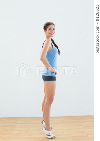 Side view of a sporty woman tip toeing 9126623