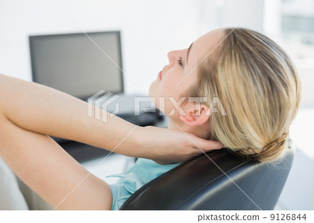 Chic businesswoman relaxing sitting on her swivel chair Chic businesswoman relaxing sitting on her swivel chair 9126844