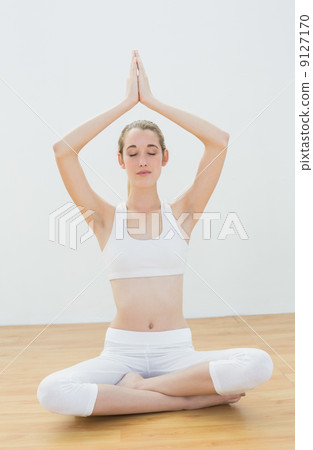 Concentrating calm woman meditating sitting in lotus position wi 9127170