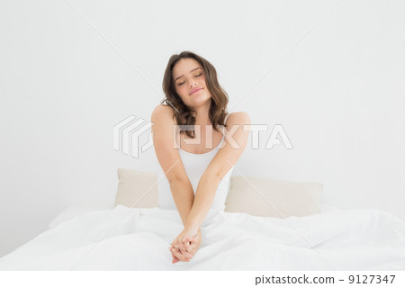 Woman stretching her arms in bed 9127347