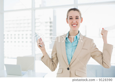Attractive cheerful businesswoman holding her smartphone Attractive cheerful businesswoman holding her smartphone 9128390