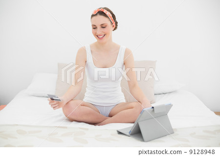 Young woman using her tablet for home shopping 9128948