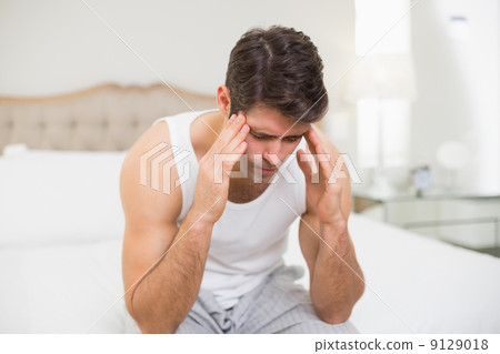 Young man suffering from headache in bed Young man suffering from headache in bed 9129018