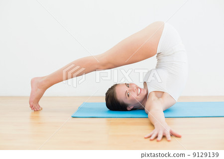 Side view of a smiling woman exercising on mat 9129139