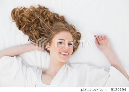 Overhead portrait of a smiling young blond in bed 9129194