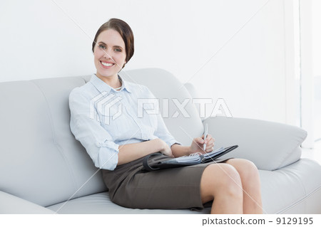 Well dressed woman using personal organizer at home Well dressed woman using personal organizer at home 9129195