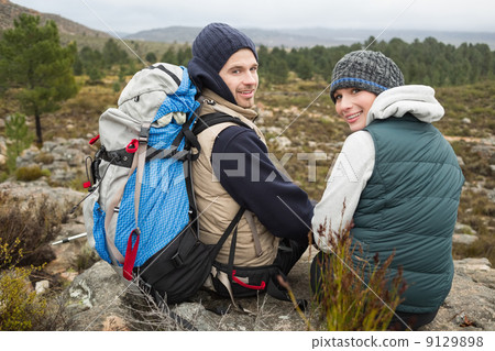 Portrait of a couple with backpack relaxing while on a hike Portrait of a couple with backpack relaxing while on a hike 9129898