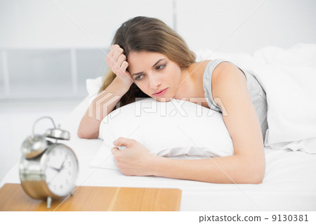 Calm attractive woman lying thoughtful on her bed Calm attractive woman lying thoughtful on her bed 9130381