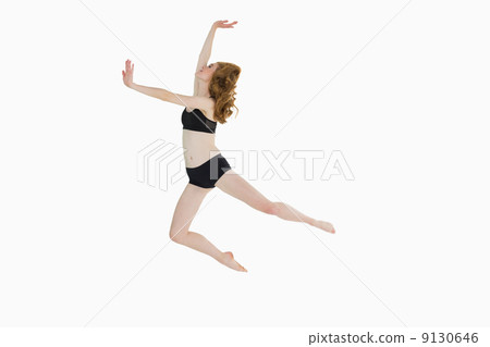 Full length side view of a sporty woman jumping Full length side view of a sporty woman jumping 9130646