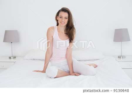Beautiful casual young woman sitting in bed Beautiful casual young woman sitting in bed 9130648