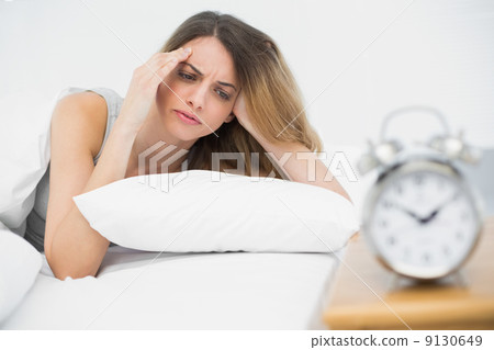 Suffering young woman having headache lying on her bed 9130649