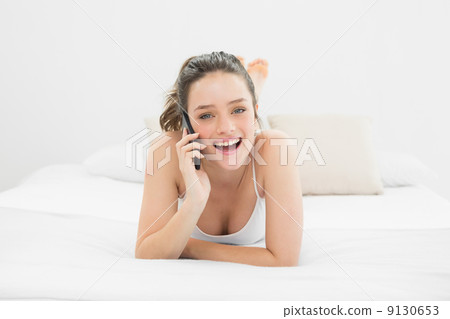 Portrait of a casual woman using mobile phone in bed 9130653