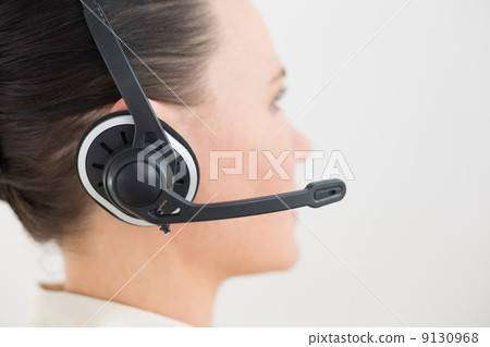 Close-up side view of a beautiful businesswoman using headset 9130968