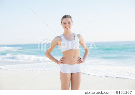 Smiling slender woman standing hands on hips Smiling slender woman standing hands on hips 9131367