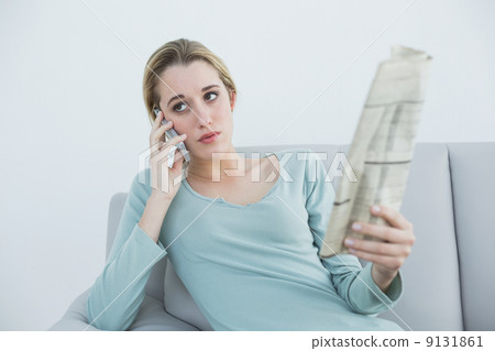 Casual serious woman phoning sitting on couch 9131861