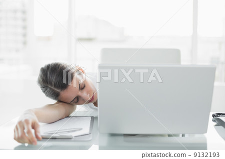 Pretty exhausted businesswoman sitting at her desk sleeping Pretty exhausted businesswoman sitting at her desk sleeping 9132193