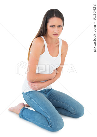 Displeased casual young woman with stomach pain Displeased casual young woman with stomach pain 9136428