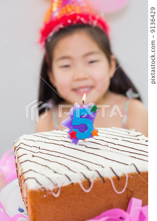 Blurred little girl with lit candle on birthday cake Blurred little girl with lit candle on birthday cake 9136429