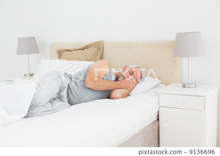 Mature man sleeping in bed 9136696